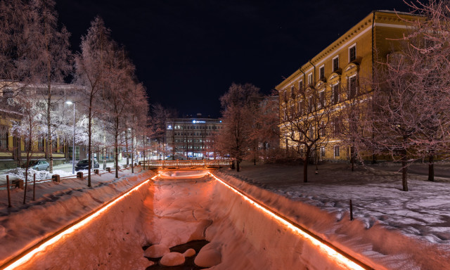 Kuvassa näkyy Oulun kaupungiojan valaistus pimeällä.