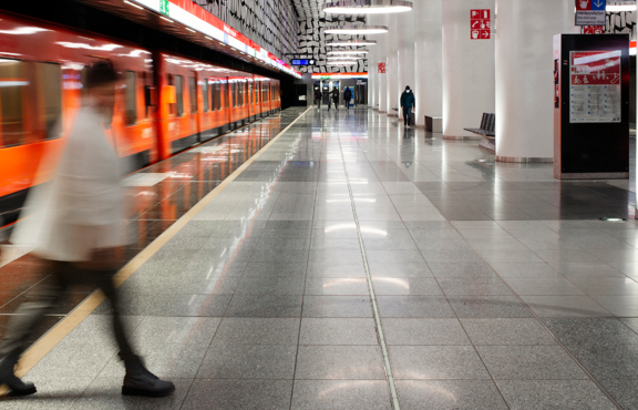 Metroasemalla kaksi henkilöä astuu laiturille.